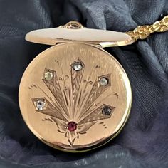 "Description: A patented design on an antique round gold filled locket necklace with an etched design and six \"paste\" stones on a new 14K gold filled chain. The front of this round antique hallmarked gold filled locket has a unique design with some etched leafy and geometric shapes accented with paste gems.  NOTE: What are paste stones? \"Paste\" stones are a type of cut glass that was produced to imitate the look of expensive gems. The most commonly used material for paste was lead glass. The Round Locket Necklace, Lead Glass, Antique Locket, Round Locket, Gems Art, Photo Pendant, Faux Stone, Red Stone, Locket Necklace