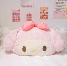 a large pink stuffed animal laying on top of a bed