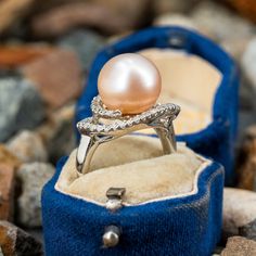 This beautiful ring is centered with one (1), post set, cultured saltwater pearl. The pearl is bordered with forty-five (45), prong set, round single cut diamonds. The ring measures 13.8mm at the top, rises 11.4mm above the finger, tapering to 2.1mm wide and 0.8mm thick at the base of the shank. This ring is currently a size 5. Akoya Pearl Rings With Diamond Accents, Round Diamond Ring With Akoya Pearl And Diamond Accents, Round Akoya Pearl Diamond Ring With Accents, Akoya Pearl Diamond Ring With Accents, Akoya Pearl Ring With Diamond Accents, Exquisite Pearl Ring With Diamond Accents, Exquisite Pearl Ring With Diamond Accents For Anniversary, Exquisite Akoya Pearl Ring For Anniversary, Exquisite Akoya Pearl Anniversary Ring