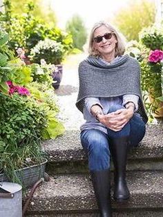 a woman sitting on steps in front of potted plants