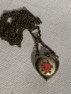 "Vintage item from 1950 32\" old brass chain Antique Perfume Bottle With Enamel ( Guilloche ) Hand Painted Rose Pendant heart with original handle chain measuring 1.5\" Please remember all items are vintage & estate found, therefore do not expect perfection as they may show some wear or imperfections only adding to the character & authenticity. I do my best to accurately describe & photograph all items. Please message me with any questions. Thank You!" Vintage Rose Gold Heart Pendant Jewelry, Vintage Rose Gold Heart Necklace, Vintage Rose Gold Locket Necklace For Valentine's Day, Vintage Rose Gold Heart Locket Necklace, Vintage Locket Necklace For Valentine's Day Formal, Vintage Rose Gold Necklace For Gift, Vintage Rose Gold Necklace For Valentine's Day, Rose Gold Vintage Necklace As Gift, Vintage Locket Necklace With Lobster Clasp