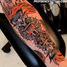 a tattoo on the arm of a man with an orange and black cross in it