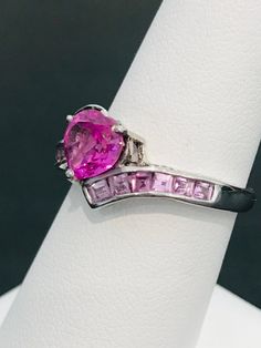 This striking heart shape pink cubic zirconia ring is handmade in sterling silver and is complete with princess cut light powder pink cubic zirconias and two natural white diamond accents. The vibrancy of the center stone will make your mouth water! The design was meticulously thought out as it includes two hearts on each side of the ring in filigree metal work. Can be sized up or down for an additional charge. Feel free to contact us with any questions you may have.