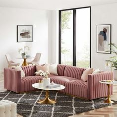 a living room with pink couches and white chairs in front of a large window