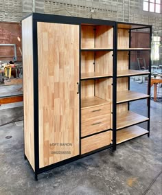 a large wooden cabinet sitting inside of a room next to a metal rack with drawers