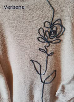 an embroidered sweater with a flower on it