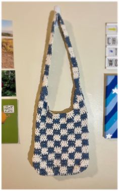 a crocheted bag hanging on the wall next to pictures and magnets,