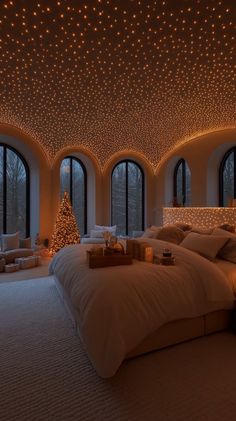 a large bed in a room with lots of lights on the ceiling and windows above it