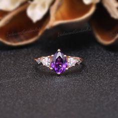 Amethyst Engagement Ring Unique Triangle Cut Moissanite Cluster Wedding Ring Art Deco Pear Shaped Purple Gemstone Rose Gold Bridal Ring RING DESCRIPTION ✦Engagement Ring ✴Center Stone - Amethyst Shape - Pear Cut Size - 6x8mm ✴Side Stones - Moissanite & Alexnadrite Shape - Triangle & Round Cut Weight - 0.26ct ✴Band Width - About 1.5mm ✴Ring Metal: Available in rose gold plated, yellow gold plated, 925 sterling silver, 10k or 14k solid rose, yellow or white gold. MAKING & SHIPPING ✦PAYMENT PLAN ♡ Elegant Amethyst Cluster Ring For Wedding, Purple Pear-shaped Ring With Prong Setting, Pear-shaped Diamond Ring With Accent Stones For Wedding, Wedding Diamond Ring With Trillion Cut Center Stone, Purple Cluster Ring With Center Stone For Wedding, Wedding Rings With Marquise Cut Gemstone, Pear-shaped Cluster Ring With Gemstone For Wedding, Purple Three Stone Wedding Jewelry, Purple Cluster Ring For Weddings, Fine Jewelry Style