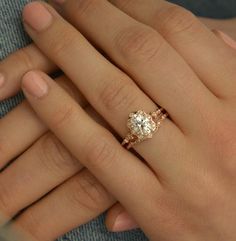 a close up of a person's hand with a diamond ring on their finger