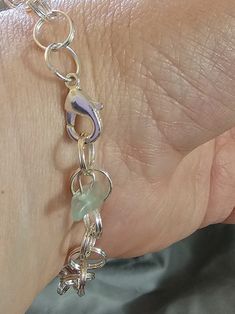 This Watermelon Falls silver-plated charm bracelet has been constructed from split rings to allow more durability as well as ability to add charms that do not have open jump rings.  The length of chainmail is approximately 8 inches (as shown in photo) not including the clasp and included charm. It has a lobster claw clasp and a small fluorospar/fluorite end charm. For smaller wrists, it will have a larger "tail." Fluospar/fluorite charm color may vary.  Watermelon Falls is designed and created by A Slice of Southern Illinois. Each charm bracelet comes in its own box. The additional charms photographed are for example only. Metal Link Bracelets With Jump Ring, Hypoallergenic Metal Charm Bracelet, Silver Link Chain Bracelet With Charms, Handmade Silver Round Charm Bracelet, Silver Bracelet With Spring Ring Clasp For Gift, Hypoallergenic Metal Link Charm Bracelet, Silver Dangle Charms Chain Bracelet, Metal Dangle Charm Bracelet For Jewelry Making, Silver Hypoallergenic Link Charm Bracelet