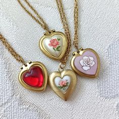 Lovely tiny and UNUSED 70S VINTAGE heart lockets available in different finished (explained below) on dainty gold plated chain measuring 16" (40cm) + 2" =  40cm +5 cm of extender chain.      OPTIONS: 1. Tiny 50s vintage Japanese porcelain heart. 2. Porcelain heart with rust orange rose. 3.  Pink enamelled copper with rose, from the 60s.  4. Red domed heart is first quality plastic.  # 2, 3 &: 4 will hold one picture each side and measure: 14mm x 16mm. ( 0,55" x 0.63"). #1 measures 15x16mm and ha Vintage Lockets Necklace, Flower Locket Necklace, Small Gold Locket, Heart Necklace Locket, Locket Heart Necklace, Necklace Heart Locket, Gold Heart Locket Necklace, Vintage Heart Necklace, Rose Locket