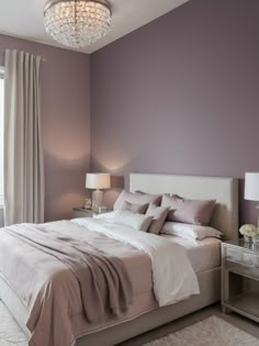 a bedroom with purple walls and white bedding, two lamps on nightstands and a chandelier hanging from the ceiling