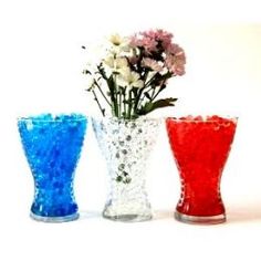 three different colored vases with flowers in them