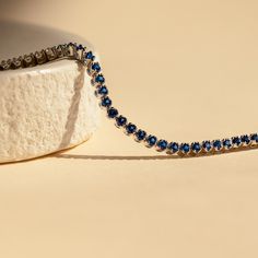 Make a shimmering statement with our Blue Sapphire Diamond Tennis Bracelet. Elegant and dainty, it adds the perfect bold, finishing touch to your outfit for special occasions like anniversaries or weddings. A minimalist accessory sure to shine and a dazzling symbol of “something blue” for brides. Material: High Quality Solid 925 Sterling Silver Finish: Sterling Silver ∙ 18K Gold Clasp: Box clasp and side prong closure Featuring a 6 inch (ONE SIZE) ~3mm Tennis Bracelet with half CZ Sapphire and h Elegant Diamond Gemstone Bracelet For Party, Timeless Blue Cubic Zirconia Jewelry, Dainty Blue Jewelry For Party, Sapphire Round Bracelets For Wedding, Sapphire Wedding Bracelets, Dainty Diamond Bracelet With Sparkling Stones For Formal Occasions, White Gold Tennis Bracelet For Party, Elegant Tennis Bracelet With Sparkling Stones For Gift, Timeless Blue Jewelry With Prong Setting