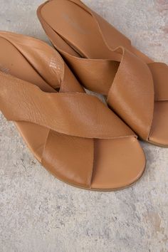 Your favourite Harli Cross Strap Flat is back in Tan! Crafted from 100% authentic leather, this ultra-comfortable sandal features the statement cross strap, cushioned sole and platform heel you love. Complete your transeasonal look with this best selling style. Leather Slide Wedge Sandals For Beach, Brown Summer Slingback Sandals With Textured Footbed, Brown Slingback Sandals With Textured Footbed For Summer, Vacation Sandals Open Toe, Spring Brown Slingback Sandals With Cushioned Footbed, Brown Cushioned Slingback Sandals For Spring, Spring Cross Strap Wedge Sandals With Cushioned Footbed, Spring Wedge Sandals With Cushioned Footbed And Cross Strap, Vacation Cross Strap Wedge Sandals