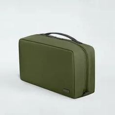 a green suitcase sitting on top of a white surface