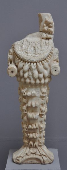 a white vase with an animal head on it