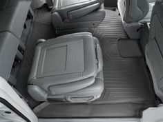 the interior of a vehicle with grey seats and gray floor mats, including one passenger's back seat