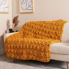 a couch covered with a yellow blanket in a living room