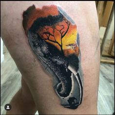 an elephant and tree tattoo on the thigh