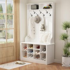 a white coat rack with shoes and hats hanging on the wall next to a door