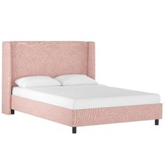 a pink bed with white sheets and pillows