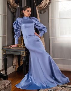 Elevate your evening wardrobe with this luxurious satin long dress in a stunning pastel blue hue. The dress features dramatic puff sleeves that add a touch of sophistication and elegance, perfect for making a statement at any formal event. The high neckline and figure-flattering silhouette create a graceful and refined look. Ideal for weddings, galas, or any special occasion, this gown ensures you'll turn heads with its exquisite design and flawless craftsmanship. Color: Pastel Blue Material: Premium Satin Details: Dramatic Puff Sleeves, High Neckline, Figure-Flattering Silhouette Occasion: Perfect for weddings, formal events, galas, and special occasions Care Instructions: Dry clean recommended to maintain the fabric's luster Make this dress yours and shine with timeless elegance! Luxury Pre-draped Satin Evening Dress, Glamorous Blue Silk Evening Dress, Luxury Satin Finish Pre-draped Evening Dress, Luxury Blue Satin Finish Gown, Luxury Blue Puff Sleeve Evening Dress, Long Sleeve Ruffle Dress, Satin Dress Long, Satin Long Sleeve, Shiny Clothes