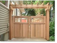 an open wooden gate in front of a house