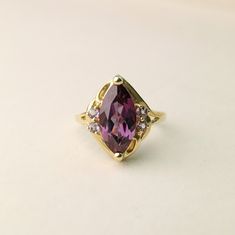 A T T R I B U T E S Vintage ∙ Rare Design ∙ Precious Gemstone Jewelry ∙ Authentic Gemstone ∙ D E T A I L S ~ Vintage Ring ~ 10K Solid Yellow Gold  ~ Marquise cut Rhodolite center stone with round Rhodolite accent stones ~ Hallmarked  ~ Gold Stamped S P E C S ~ Total Weight: 3.7g ~ US Size: 8 ❤️ IS ∙ T H I S ∙ A ∙ G I F T ? ❤️ All items are elegantly packaged like gifts - whether they're for you or someone else to enjoy :) Let us know if you want us to add some special touches when we package you Fine Jewelry Birthstone Rings For Collectibles, Marquise Jewelry With Gemstone Accents For Anniversary, Fine Jewelry 14k Gold Marquise Amethyst Ring, Marquise Birthstone Ring In Fine Jewelry Style, 14k Gold Marquise Amethyst Ring Fine Jewelry, Marquise Amethyst Ring In 14k Gold, Formal Marquise Birthstone Ring With Accent Stones, Fine Jewelry Amethyst Marquise Ring, Amethyst Marquise Ring For Gift