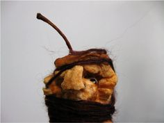 a close up of a stuffed animal made out of bread and other things on a white surface