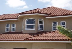 a house with red tile roof and white windows