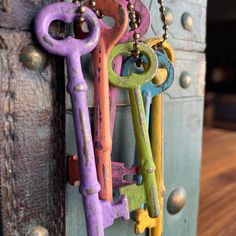 several different colored keys are hanging on a door