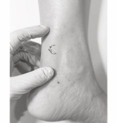 a person's foot with a small tattoo on the left side of their ankle