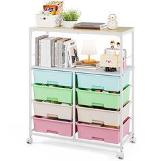 a white shelf with several drawers and some books on top of it next to a lamp