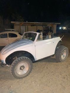 an old white truck parked in the dirt