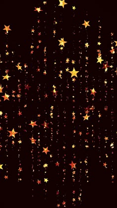 gold stars are falling down on a black background