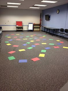 an empty room with several tables and chairs on the floor covered in colored sticky notes