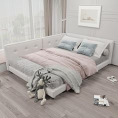 a white bed sitting on top of a hard wood floor next to a large window