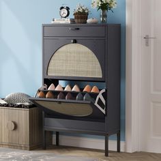 a shoe rack with shoes in it next to a blue wall and wooden flooring