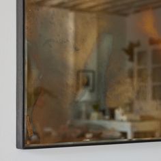 the reflection of a kitchen sink and counter top in a glass doored wall mirror