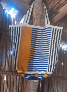 an orange and blue striped bag hanging from a tree