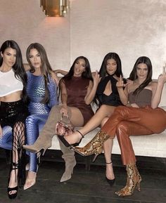 four women sitting on a couch posing for the camera