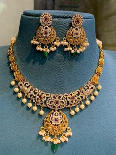 This set goes with all festive occasion dresses and it is a Statement piece . DETAILS: Includes one necklace and two earrings. Length : 14cm  Type : Close neck set or adjustment can be made with extension thread  Material: Imitation gold, kemp stones.  Finish: Premium-quality, light-antique gold finish.  PRODUCT CARE: - Avoid contact with heat/fire, water, and chemicals such as perfumes or any sprays to prevent product damage.  - Store it in the white base cover and box provided by us . 22k Gold Necklace Indian Jewelry Kameswari Jewellers, Luxury Temple Jewelry Necklaces For Festive Occasions, Luxury Temple Jewelry Beaded Necklaces For Festivals, Luxury Kundan Temple Jewelry Necklace, 22k Gold Necklace Kameswari Jewellers, Luxury Traditional Temple Necklace With Gold Beads, Affordable Gold Kundan Necklace For Festive Occasions, Luxury Round Temple Necklace For Gift, Festive 22k Gold Luxury Temple Necklace