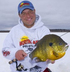 a man holding a large fish in the snow