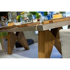 a wooden table topped with lots of vases filled with flowers