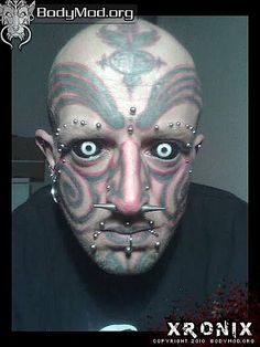 a man with tattoos and piercings on his face