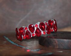 "Beautiful bracelet with red rhinestone crystals, great statement piece! Pageant, prom, or bridal! Size: .75\" wide Style: stretch bracelet color: red crystals / silver base metal red/ gold base metal Looking for matching earrings or necklace? Browse through our listings or send us a message! :) https://www.etsy.com/listing/507893090/red-rhinestone-earrings-large-crystal?ref=shop_home_active_3 https://www.etsy.com/listing/551764936/red-rhinestone-necklace-and-earrings-set?ref=shop_home_active_15 Prom Bracelet, Red Rhinestone Earrings, Red Bracelet, Red Prom, Large Crystal, Red Bracelets, Red Rhinestone, Rhinestone Bracelet, Red Crystals