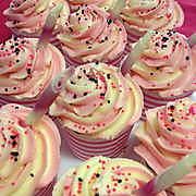 pink cupcakes with sprinkles on them