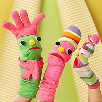 two children's legs wearing colorful socks and mittens, one holding a toy